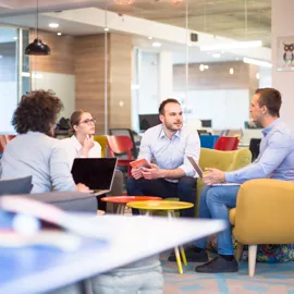 Liten gruppe ansatte og deltakere sitter og snakker