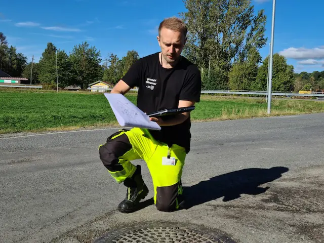 Martin Stensland ute med en plantegning og nettbrett
