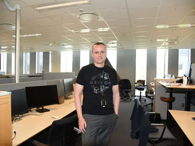  Arthur Sund stående i et kontorlandskap