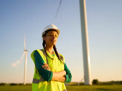 Kvinnelig arbeider foran vindmølle