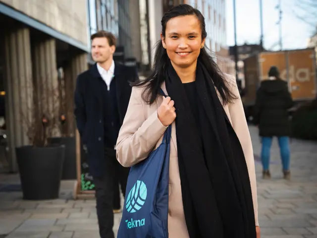 Kvinne med Tekna-veske og mann i bakgrunnen