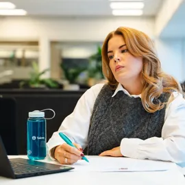 Ung kvinne funderer foran PC