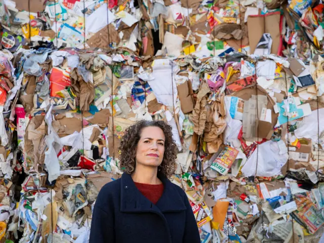 Kvinne foran et berg av søppel