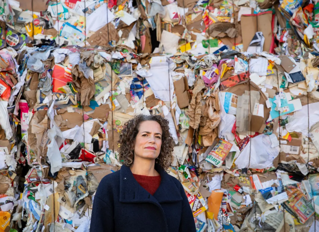 Kvinne foran et berg av søppel