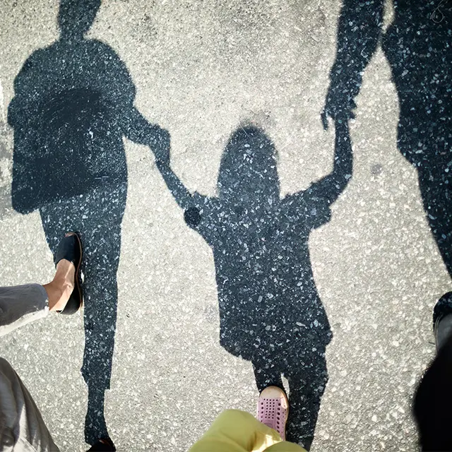 Skygge av barn som holder hender