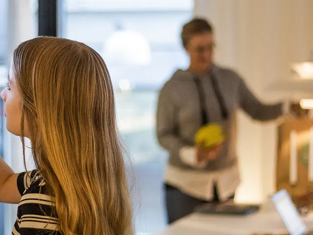 En ung jente trykker på en styringsflate i et smarthus med mor, far og bror i bakgrunn