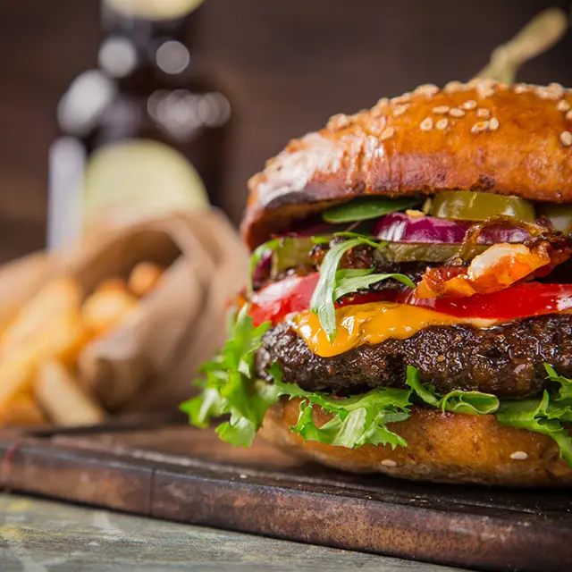 Burger med fries i bakgrunnen