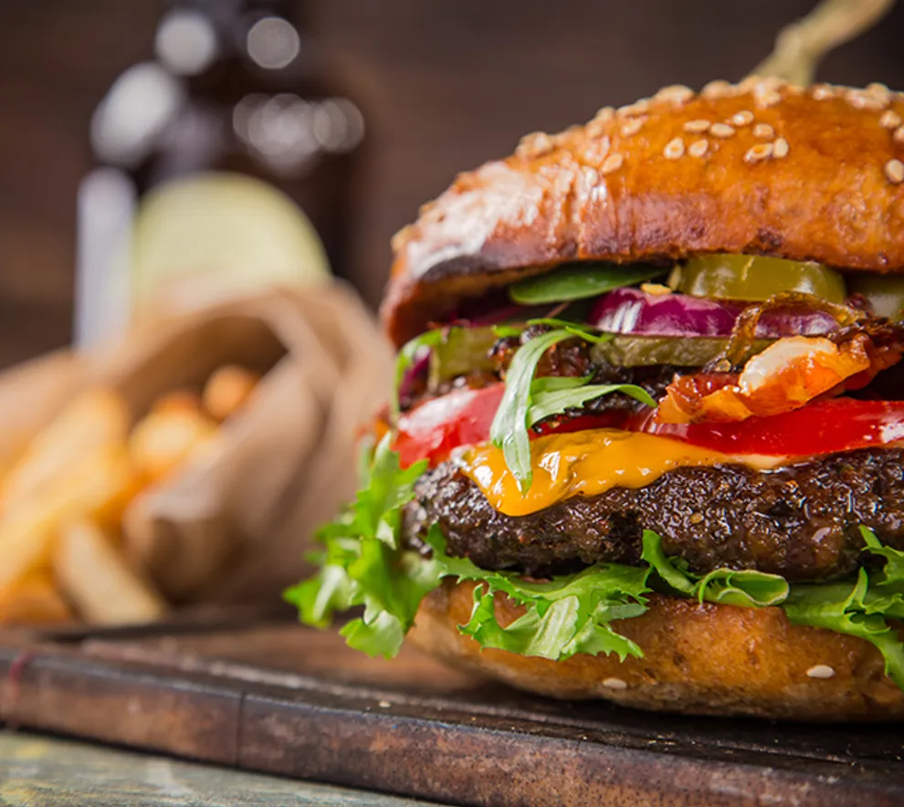 Burger med fries i bakgrunnen