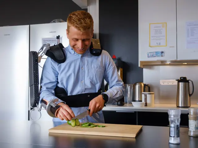 En mann bruker et eksoskjelett under matlaging