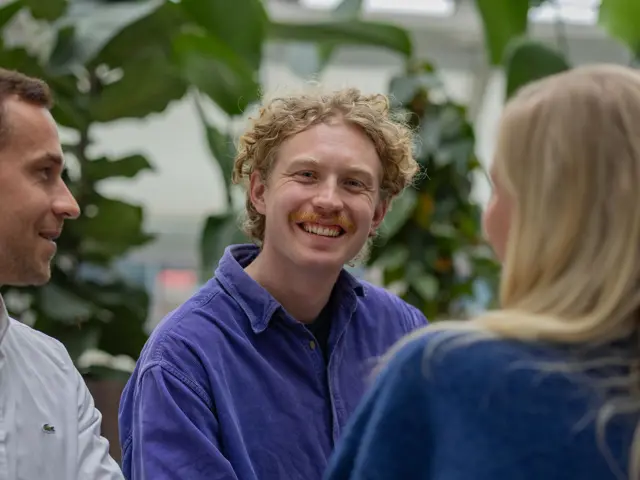 Smilende ung mann med venner