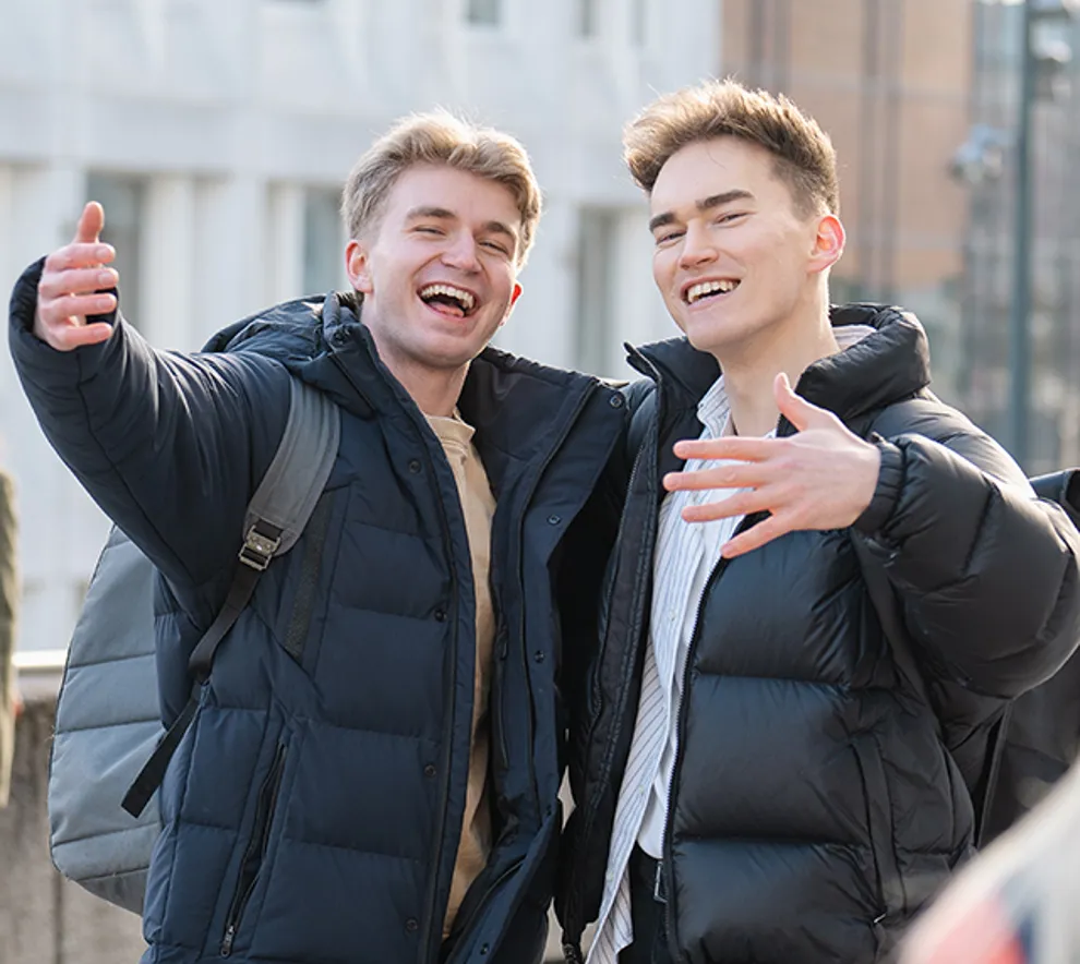 To kompiser som holder rundt hverandres skuldre