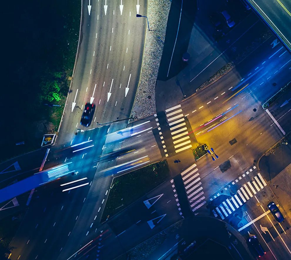 Dronebilde tatt på kvelden av stort trafikk-kryss i storby
