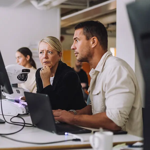 Mann og kvinne som ser på pc