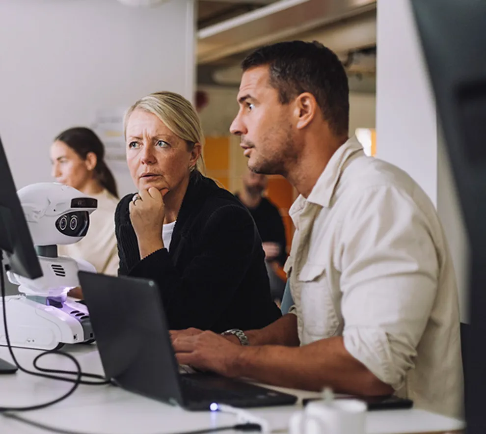 Mann og kvinne som ser på pc