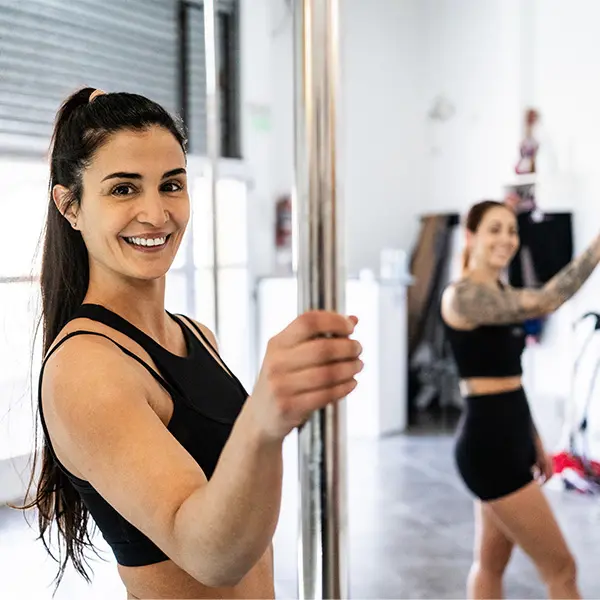 To kvinner som holder i en poledancestang