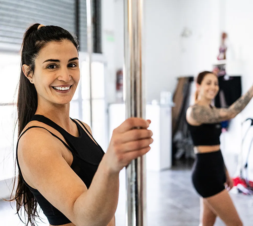 To kvinner som holder i en poledancestang