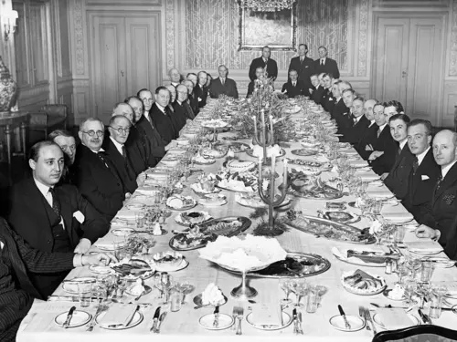Et festpyntet bord med stivpyntede herrer på hver side