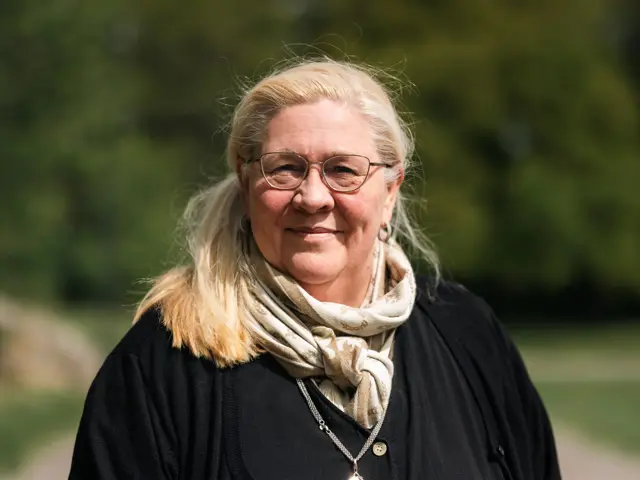 Portrett av kvinne  med lyst hår i svarte klær