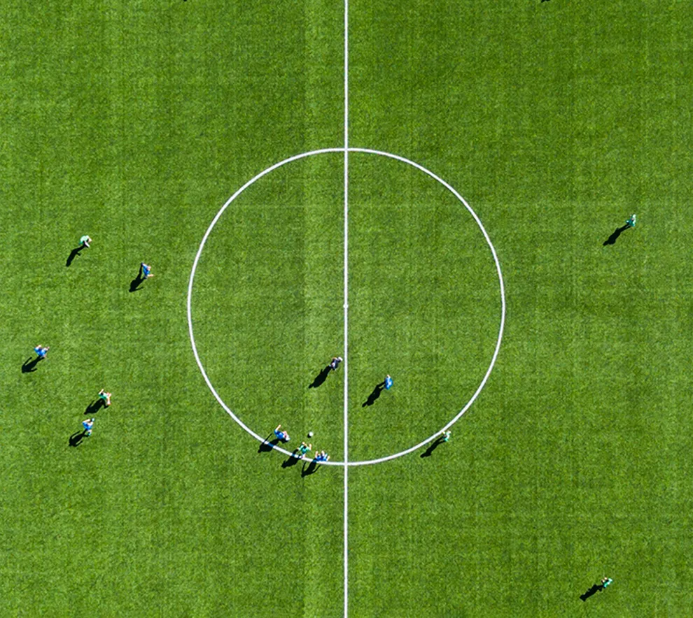 En fotballbane med spillere fra to lag sett ovenfra