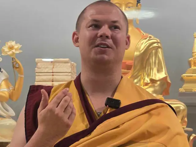 Mann med buddhistiske klær snakker mot kamera