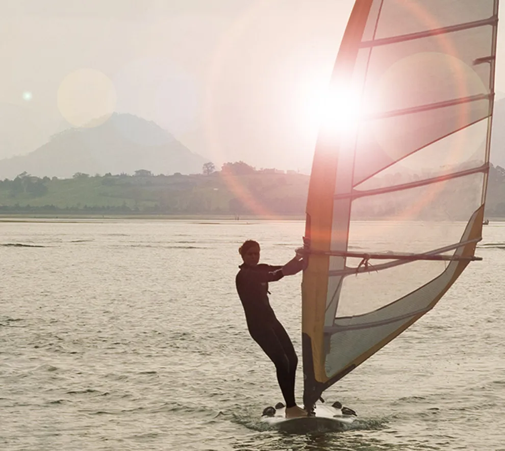 Person som windsurfer, vann og sol