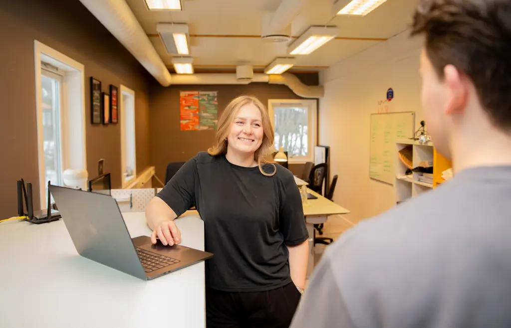 Kvinne i kontormiljø ser inn i rommet