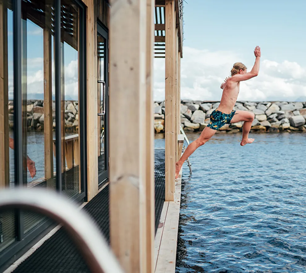 Mann som hopper fra badstuebåt
