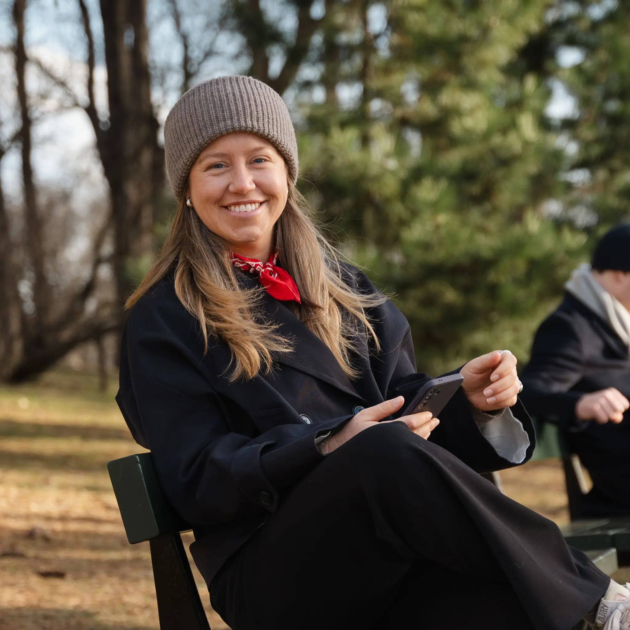Kvinne på benk utendørs smiler