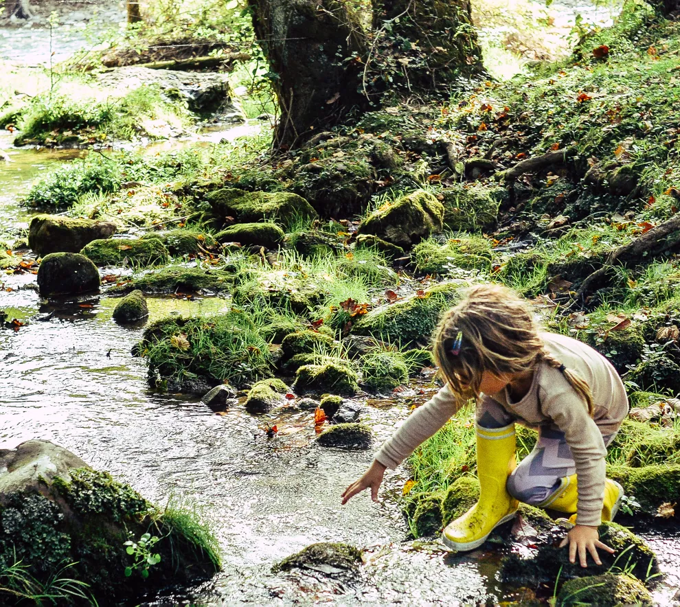 To barn som leker ved en bekk