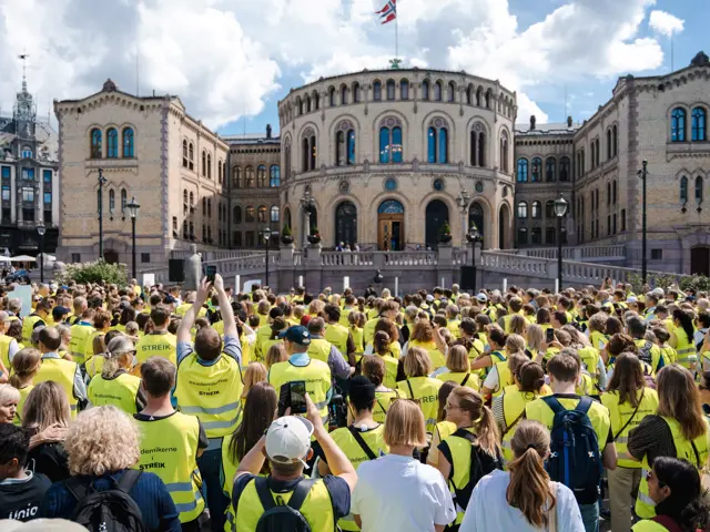 folk i gule vester foran Stortinget