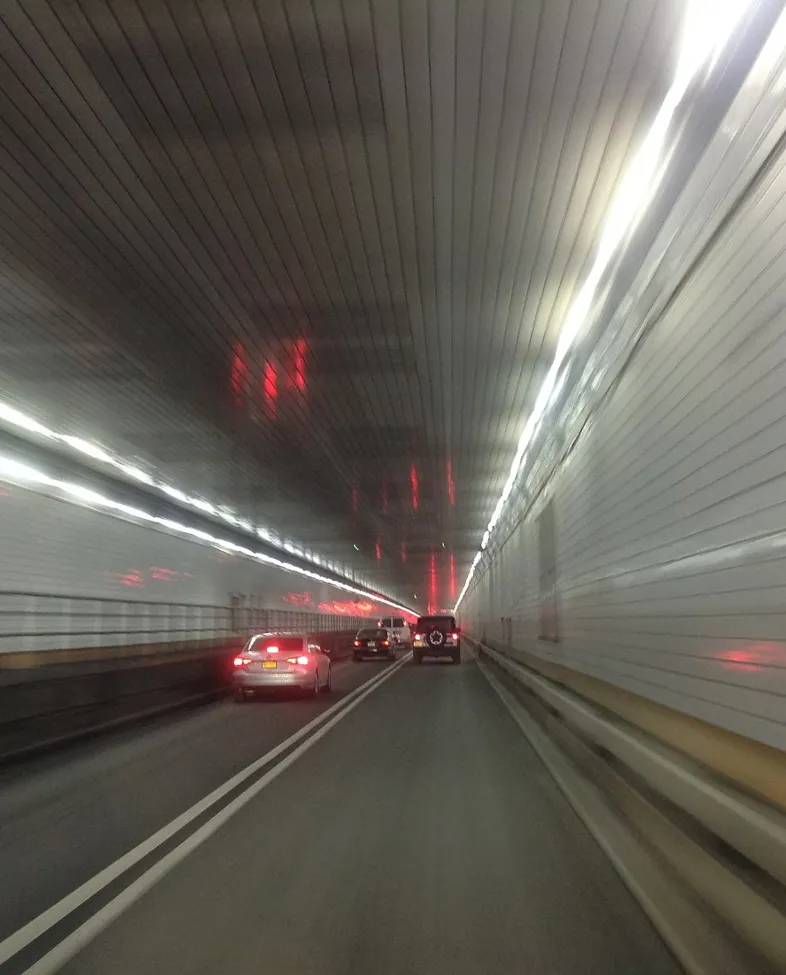 Biler kjørende i tunnel med hvite fliser på veggen