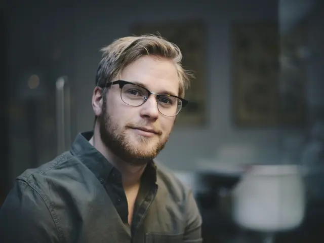 Mann med briller portrettbilde, ser tankefullt inn i kameraet