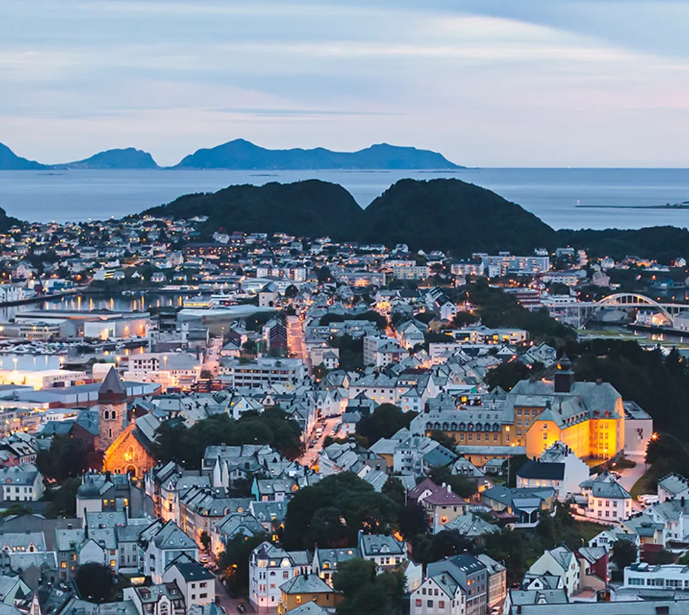 Stavanger by i skumring med fjell i bakgrunnen
