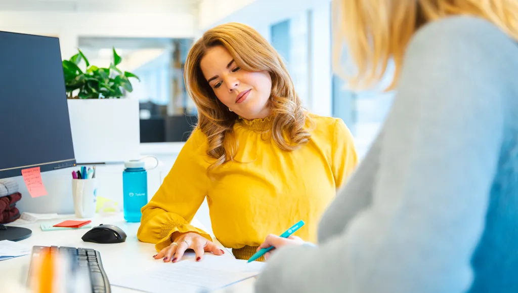 Ung kvinne i samtale med kollega