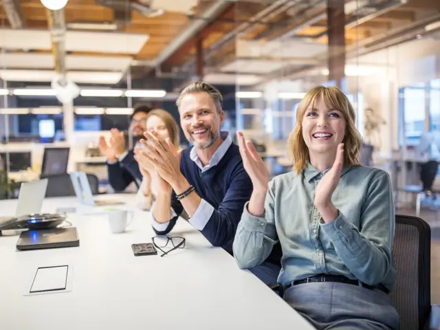 Kolleger klapper og smiler 