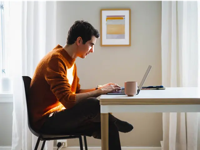 Ung mann ser på sin laptop