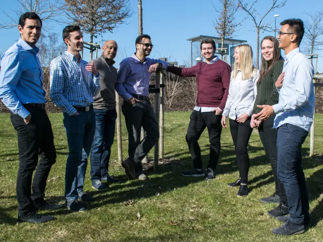 Åtte personer ute på en gressplen i solskinn