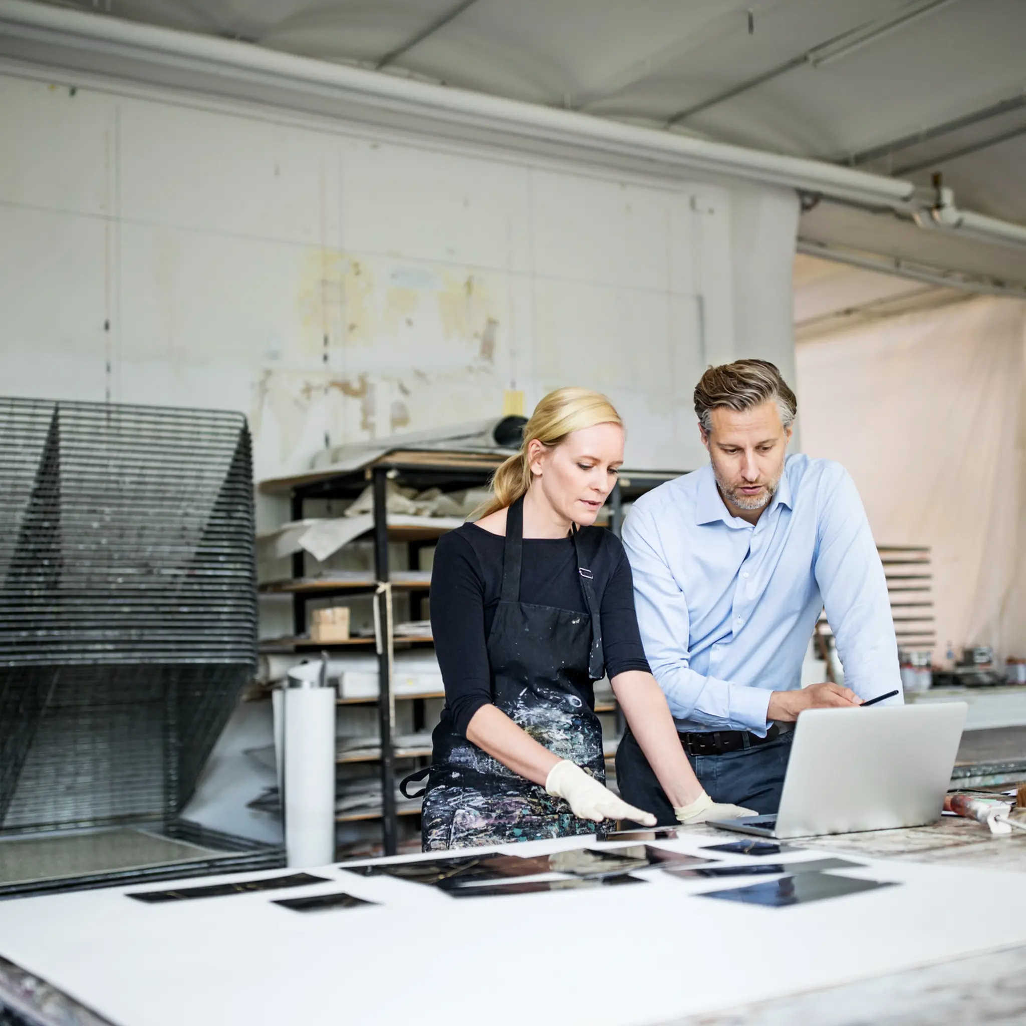 Illustrasjonsbilde av en leder som snakker med en kvinne i et kunstverksted.