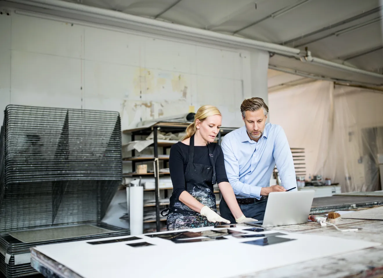 Illustrasjonsbilde av en leder som snakker med en kvinne i et kunstverksted.