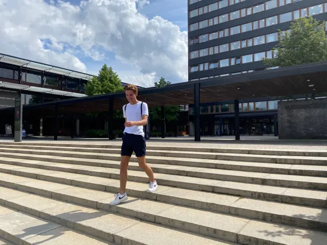 Ferdinand Hegelstad går ned en trapp i solen