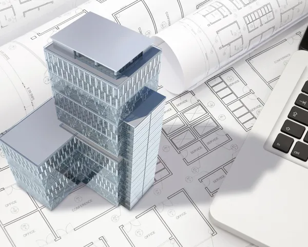 Illustrasjonsbilde av en 3D modell av en skyskraper på en pult ved siden av en laptop