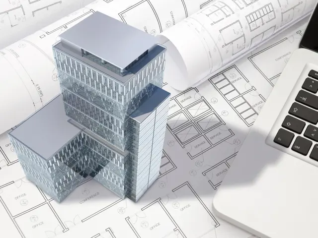 Illustrasjonsbilde av en 3D modell av en skyskraper på en pult ved siden av en laptop