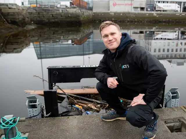 Mann sitter på kne i havn