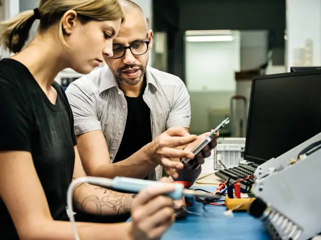 ung kvinne læres opp på elektronikklab