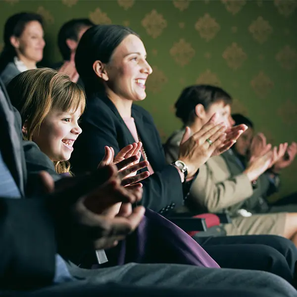 Barn og mor som sitter i publikum