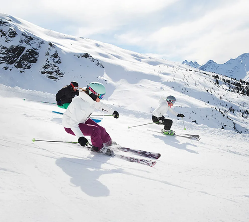 Tre personer som står på slalåm