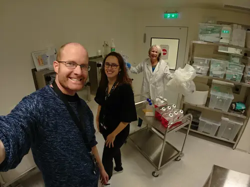 Andreas Dietzel med to kvinner i en lab smiler til kamera