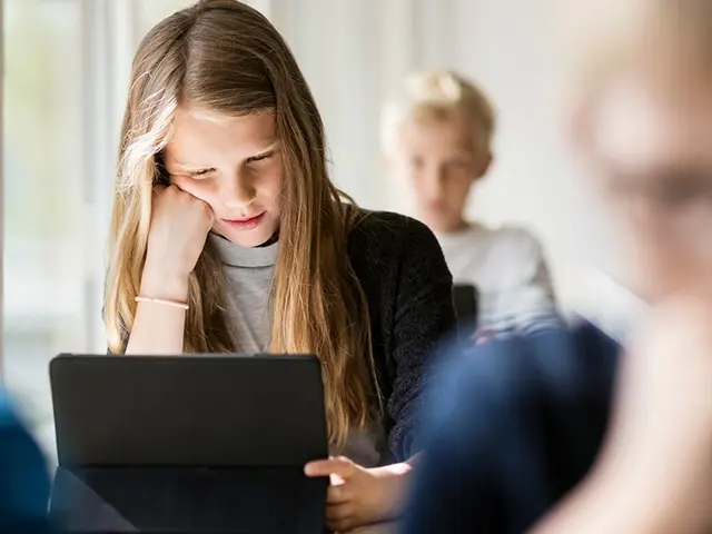 Jente foran skjerm på skolen