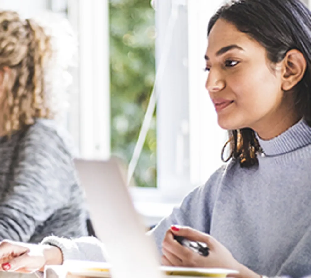 Jente som sitter å jobber ved en pc