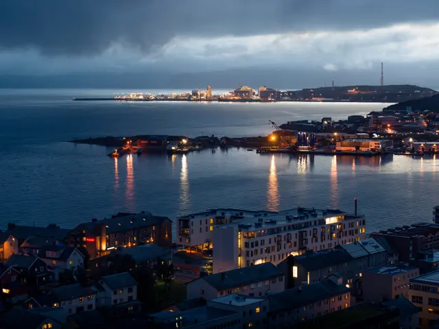Illustrasjonsbilde av en lyst opp by ved havet om natten